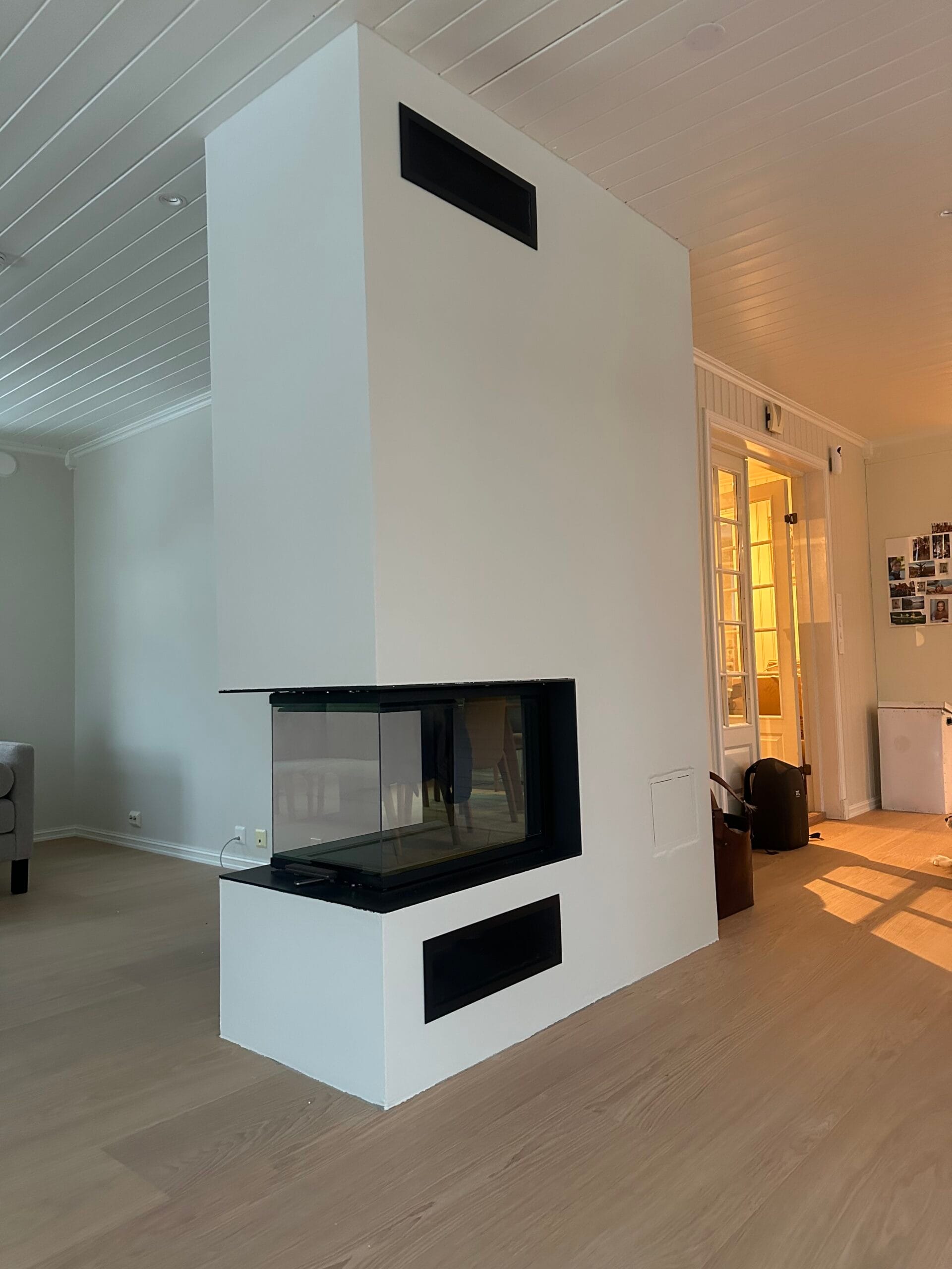 Moderne hvit peis med glass på tre sider i en stue